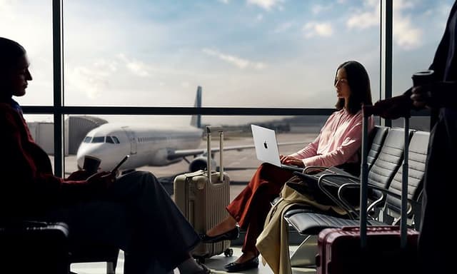 Apple - B2B - Businesswoman at an airport with a MacBook