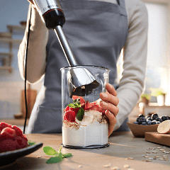 Kvinna som mixar yoghurt och frukt med en Bosch stavmixer