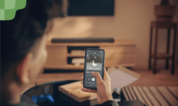 Person spiller musik på deres telefon og streamer det til soundbaren