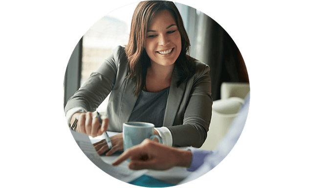 Smilende kvinne som snakker med en kollega i et møte