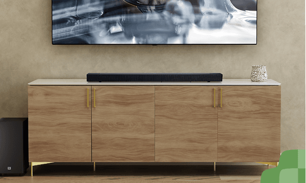 Soundbar kaapin päällä, jonka yläpuolella seinään kiinnitetty televisio