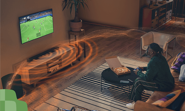 Mies pelaa peliä televisiolla, johon on yhdistetty JBL SB595 -soundbar äänentoistoa varten