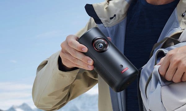 Mies asettaa Capsule 3 Laser -projektorin takkinsa sisätaskuun