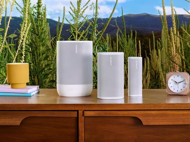 Sonos-tuoteperhe, valkoiset Sonot-kaiuttimet puisen pöydän päällä