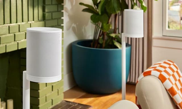 Två vita sonos högtalare bakom soffa för surroundljud av biokvalitet