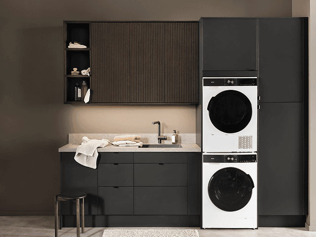 Kalusteisiin sijoitettu pesutorni kodinhoitohuoneessa