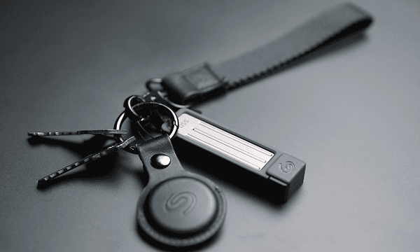 En Seagate USB‑enhed fastgjort til en nøglering med nøgler og et lædermærke på en mørk overflade