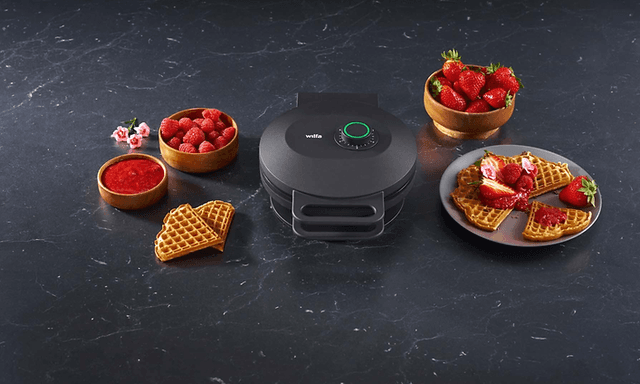 Wilfa Joy vaffeljern på et bord med færdige vafler og bær omkring