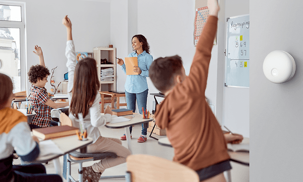 Airthings on the classroom wall where teacher is having a lessong to her students