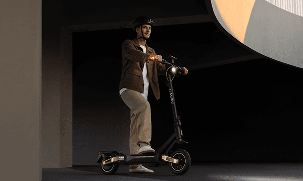 En mand kører på sit Navee ST5 Pro el‑løbehjul under en moderne bebyggelse