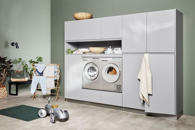 Kodinhoitohuone, jossa pyykinpesukone ja kuivaurumpu integroitu Integra Steel Grey -sarjan kaapistoihin