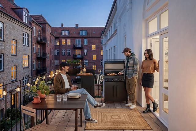 Vari-kesäkeittiö kerrostaloasunnon terassilla, jonne on kokoontunut ystäviä viettämään aikaa