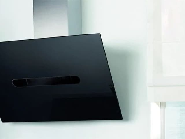 Modern köksfläkt i svart, ser nästan ut som en platt TV som lutar.