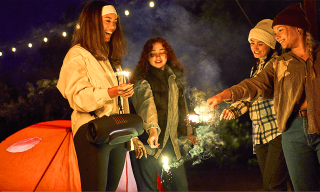 Fire kvinder nyder en campingtur med en JBL Xtreme 5‑højttaler