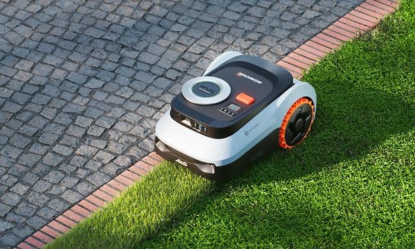 Navimow kantklipper gräsmattan brevid en gång med plattor