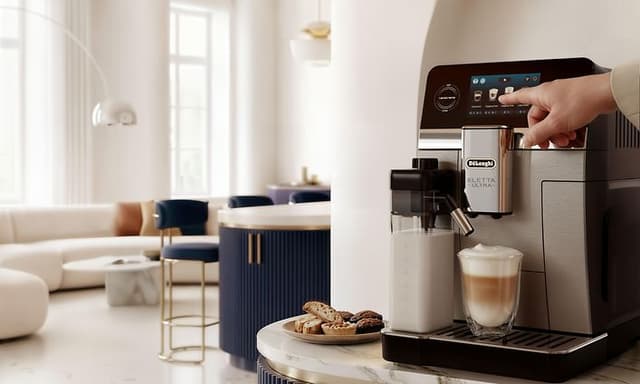 DeLonghi Eletta Ultra -kahvikone marmoripöydällä Cappucino-kahvijuoman ja keksien kera