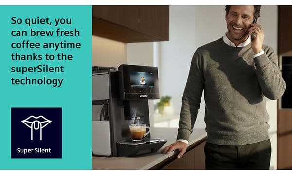En mann står ved en Siemens espressomaskin som brygger kaffe mens han snakker i telefonen.