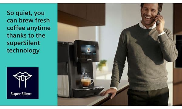 En mann står ved en Siemens espressomaskin som brygger kaffe mens han snakker i telefonen.
