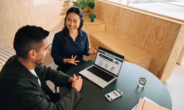 Elgiganten-anställd och kund som arbetar med Apple Business-verktyg
