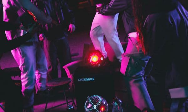 En Soundboks Lightboks står på et bord, mens folk danser omkring den