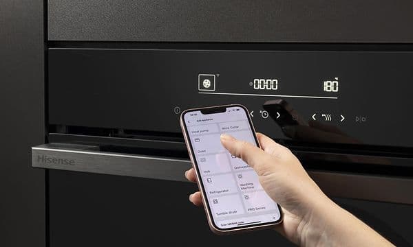 En person som använder ConnectLife-appen på sin smartphone för att styra och övervaka Hisense-pizzaugnen.