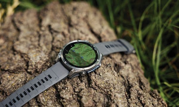 En Fenix 9 Pro-smartklokke som ligger på en tømmerstokk.