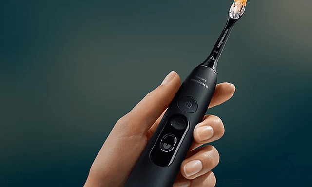 En hånd som holder rundt en sort Philips Sonicare DiamondClean elektrisk tannbørste.