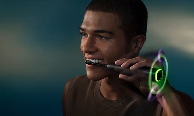 En mann som pusser tennene med Philips Sonicare DiamondClean elektriske tannbørste.