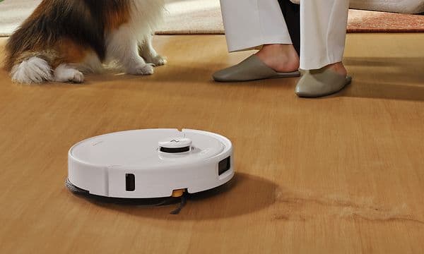 Valkoinen Roborock Qrevo 2 Pro harjaa lattiaa naisen ja koiran vieressä