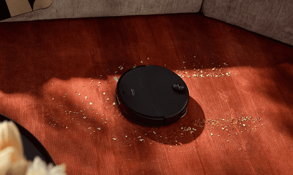 Musta Roborock Saros 20 Neo -robottipölynimuri siivoaa murusia lattialta suurella imuteholla