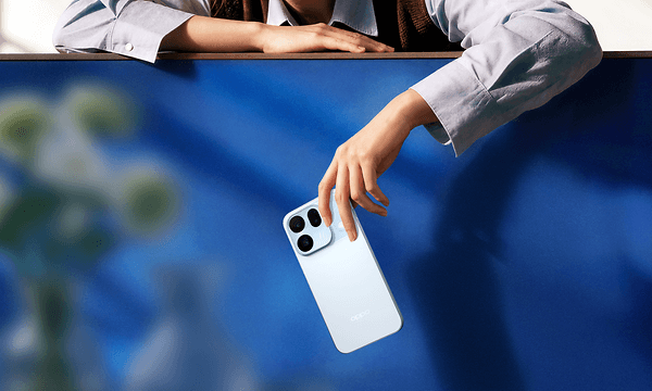 Person holder OPPO Find X10 i hånden foran en blå baggrund