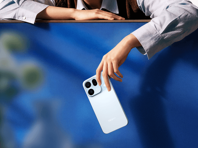 Person holder OPPO Find X10 i hånden foran en blå baggrund