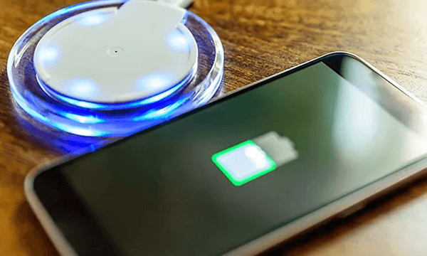 smarttelefon ligger ved siden av trådløs lader