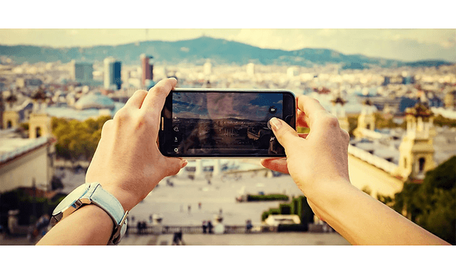 Hænder der tager et billede med sin smartphone på en rejse