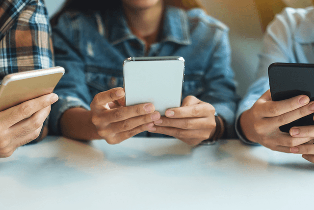 Tre unge der bruger deres smartphones