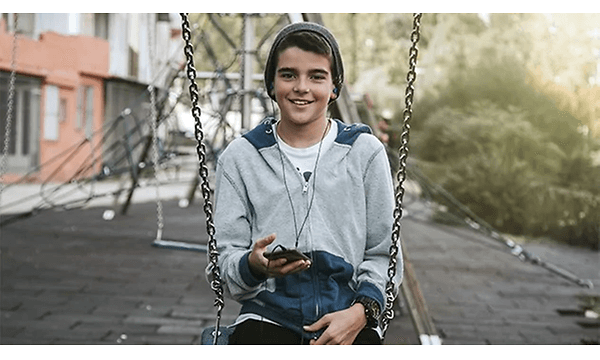 Dreng på en gynge der lytter til musik