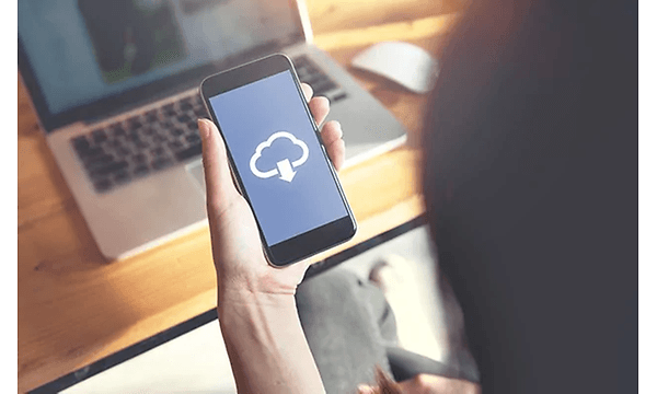 Kvinde med et billede af en cloud-tjeneste på sin telefon