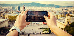 En kvinna tar en bild av sin resedestination med sin smartphone.