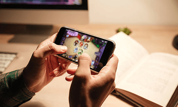 Närbild: Person som spelar spel på mobiltelefon.