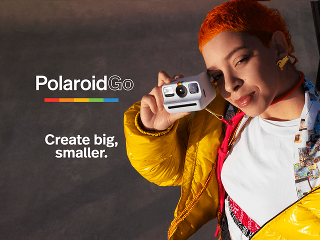 Pige med orange hår og gul jakke, holder et Polaroid Go-kamera med teksten “Create big, smaller"