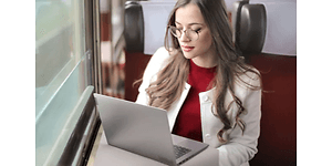 Kvinne leser på en Lenovo ThinkBook på et tog