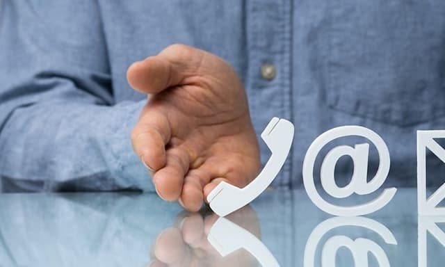 Kontaktuppgifter: Två händer visar fram en telefon, ett @ och en mail ikon