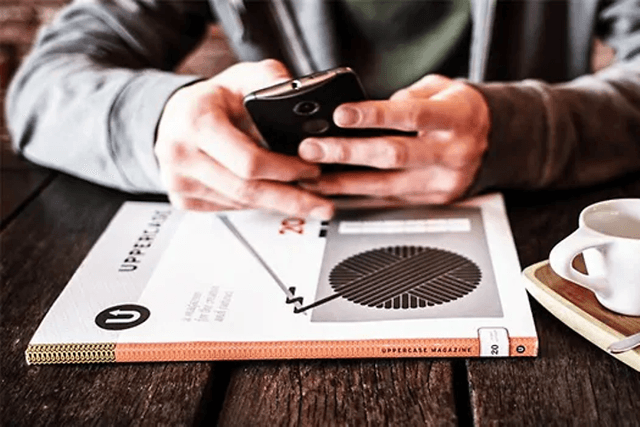 Person der bruger smartphone ved et bord