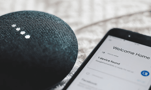 Google Home Mini og smartphone på et bord